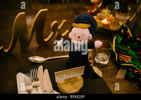 a rustic wooden wedding breakfast set up with a crochet groom doll Stock Photo