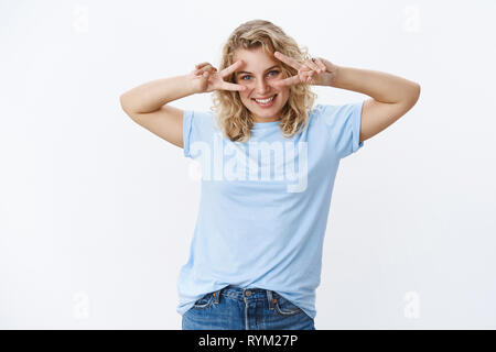 Disco always in trend. Girl having fun feeling happy and joyful as showing peace or victory signs over eyes and smiling broadly, delighted at camera Stock Photo