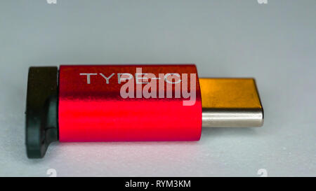 The small red USB-C adapter on the table with the micro port on the side Stock Photo