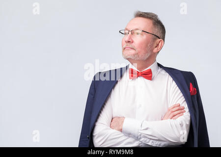 Senior man wearing eyeglasses aand blue suit smiling warmly and confident. Stock Photo