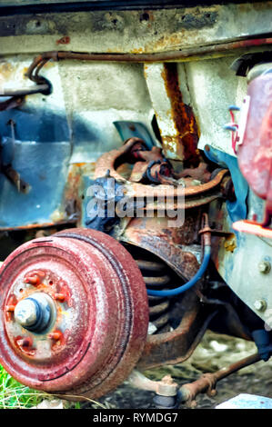 Close up shot of the rusting wheel hub of a Lincoln Continental car left abandoned adjacent to a derelict factory building in Pontiac, Michigan, USA. Stock Photo