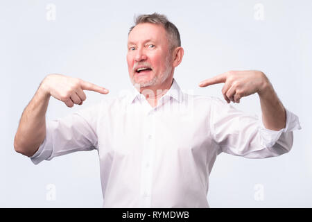 Senior man pointing to himself with index finger. He is proud of himself Stock Photo