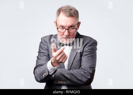 Angry senior man standing and looking at camera and accusing. Stock Photo