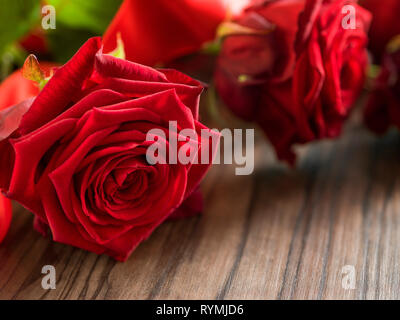 funeral and mourning concept - red rose flower on wooden coffin. Close up Stock Photo