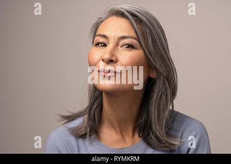 Charming Asian mature woman smiles at camera Stock Photo