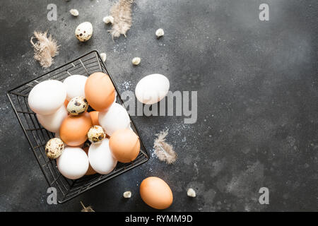 Organic white and brown chicken eggs in bowl. Top view. Vintage dark. Stock Photo