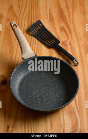 New non-stick frying pan on wooden table - closeup Stock Photo
