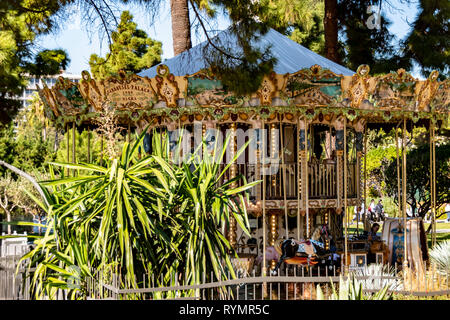 Nice, France - October 4, 2018: View to a park with a historic carousel under palm trees in Nice. Stock Photo