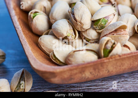macro color photo of pistachios in a wooden bowl Stock Photo