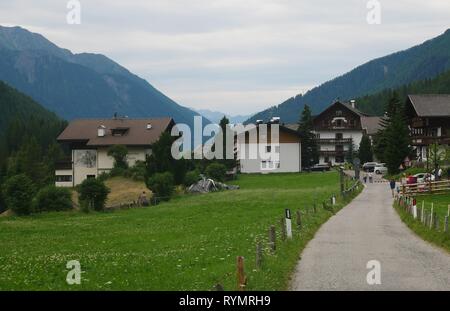 Walkers walking through a village in the Ahrntal Valley, South Tyrol, Italy Stock Photo
