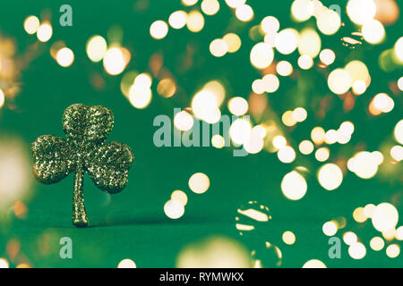 Glitter shamrock on green paper background. St Patricks day symbol. Irish National holiday concept. Horizontal, wide screen banner format. Bold festiv Stock Photo