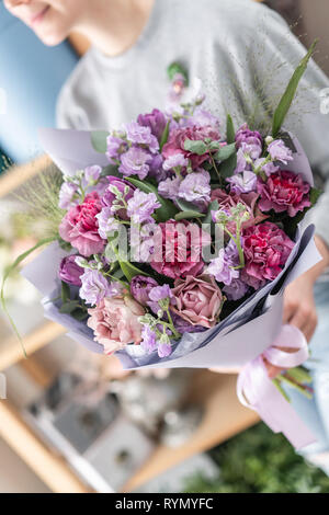 beautiful fresh cut bouquet of mixed flowers in woman hand. the work of the florist at a flower shop. Spring mood Stock Photo