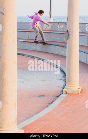 Imperia, IM, Liguria, Italy - 29/02/2018: A young boy jumping on the skateboard in a square during a sports competition of the city of Imperia. Stock Photo