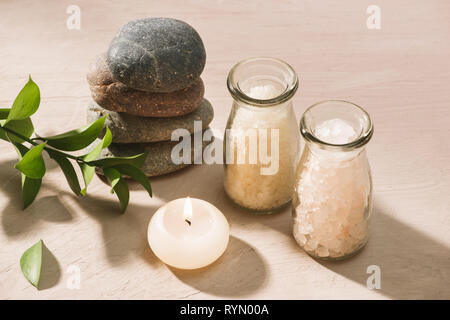 Burning candle in water. Spa setting with salt and pebbles on wooden background Stock Photo