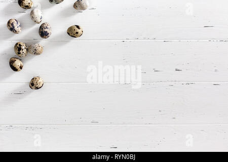 Creative Top view flat lay holiday composition Easter quail eggs on white wooden minimal background copy space Template Easter day seasonal frame. Har Stock Photo