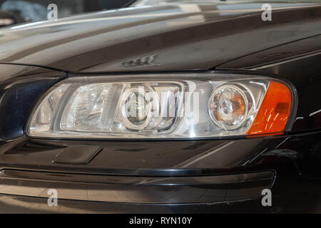 Novosibirsk, Russia - 08.01.18: Front headlamp view of black used Volvo S60 car stands in the auto showroom sale after washing Stock Photo