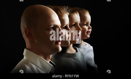 Father and sons, the concept of genetics and heredity. Young man and sons of different ages, portrait in profile on black background Stock Photo