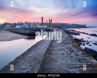 Pink sky at dusk at the harbour and St Andrews Abbey ruins St Andrews Fife Scotland Stock Photo