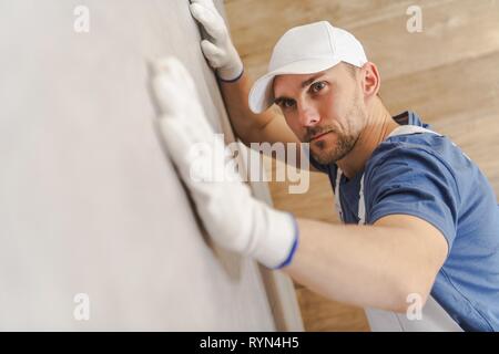 Professional Tile Installer and Quality Check on Ceramic Tiles Wall Inside a Bathroom. Construction Industry. Stock Photo