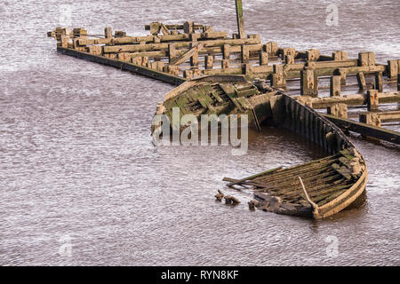 A sunken rowing boat  and a wooden jetty in the River Tees at Middlehaven, Middlesbrough, England,UK Stock Photo