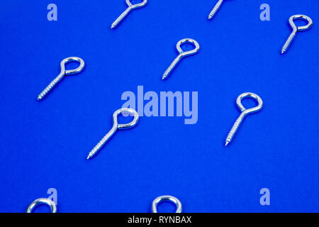 Pattern of hook screws on blue background Stock Photo
