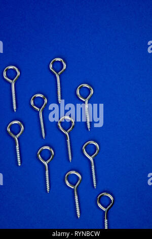Pattern of hook screws on blue background Stock Photo