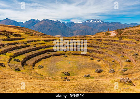 A woman performing yoga exercises in the Inca site of Moray, famous for its circular terraced field, used for agriculture science, Cusco, Peru. Stock Photo