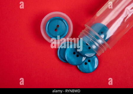 blue buttons from a button box on a red background Stock Photo