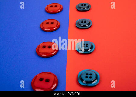 blue buttons on red background and red buttons on blue background separated in the middle Stock Photo