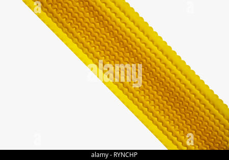 Raw Italian pasta called mafaldine on a white background , flat and wide pasta with wavy edges on both sides Stock Photo