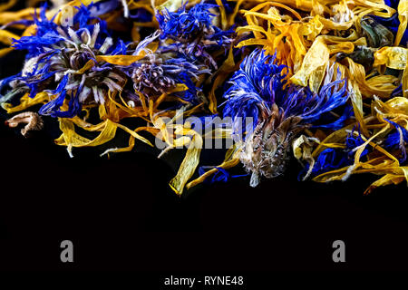 dried flowers blue and yellow on black background Stock Photo