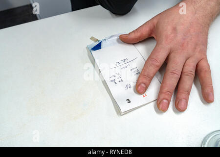Close up photograph of a waiter's hands writing on order pad and taking customers Breakfast Order in a cafe