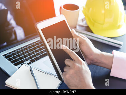 Engineer holding a blank tablet screen for tablet engineering application mock up Stock Photo