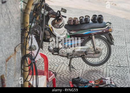 Ho Chi Minh City, Vietnam - January 8, 2019: Selling shoes in the street from the seat of a motorbike. Small business in Saigon. Vietnamese lifestyle. Stock Photo