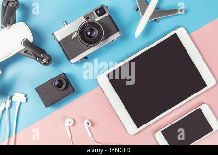 Travel gadgets flatlay on blue and pink background for travel concept Stock Photo