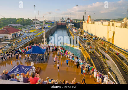 Panama Canal  cruise ship passengers  on bow deck watch ship enter Gatun  Locks as canal doors open Stock Photo