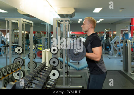 Young man doing the exercises on biceps lifting barbell for good body in fitness gym, bodybuilder, healthy lifestyle, exercise fitness, workout and sp Stock Photo