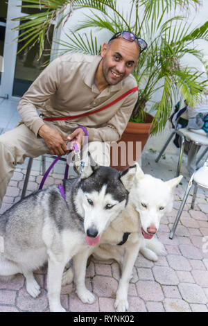 Miami Florida,Temple Israel,Bow Wow Palooza Interfaith Blessing of the Animals,owner,dog dogs,two,dogs,pet pets,Siberian Husky,leash,lead,sitting seat Stock Photo