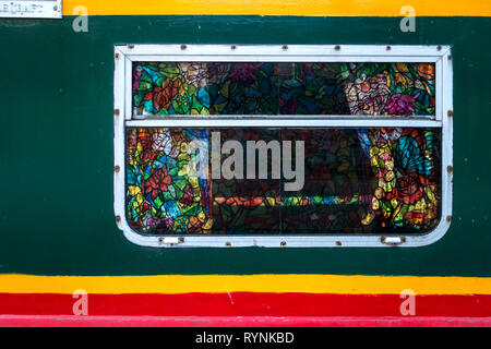 Close up image of Narrowboat rectangular Stained Glass window with Aluminium frame showing open curtains and colourful speckles of glass  window Stock Photo
