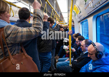 Tube commuters time, commuters reading and using smartphones on the London Underground Tube Stock Photo