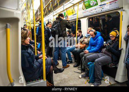 Tube commuters time, commuters reading and using smartphones on the London Underground Tube Stock Photo