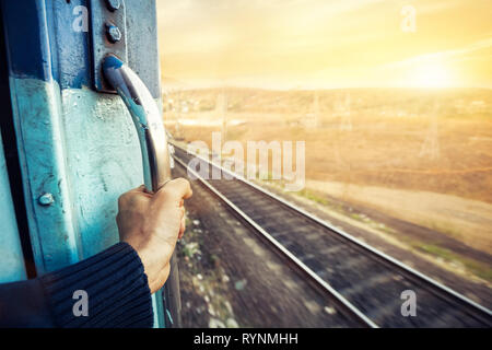 Man in the train passing desert area at sunset sky background in Rajasthan, India Stock Photo