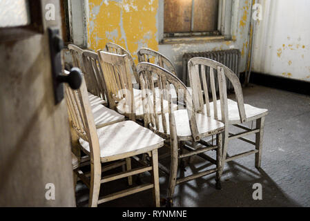 Interior of Decaying Structure Showing Stacked Chairs Stock Photo