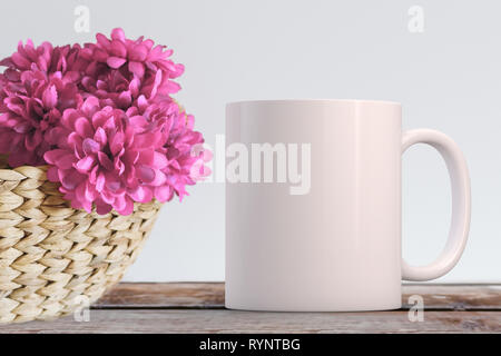 Blank White Mug coffee mug next to silk flowers in a basket. Perfect for businesses selling mugs, just overlay your quote or design on to the image. Stock Photo