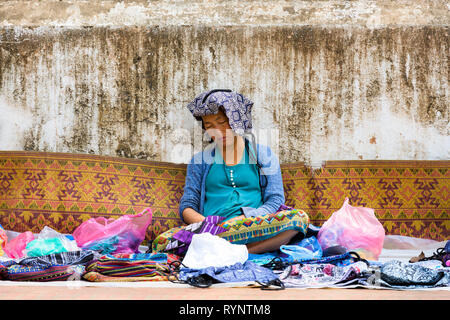A beautiful Laotian woman is sleeping in a street market in Sisavangvong Road, Luang Prabang, Laos.