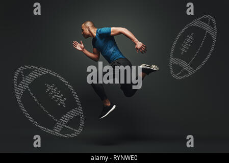 Portrait of african american man in sportswear. He is in the position for a run. Creative rugby balls painted on the background. Horizontal shot. Full-length. Side view