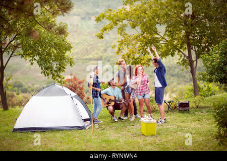 Young women and men enjoying in free time in beautiful green nature Stock Photo