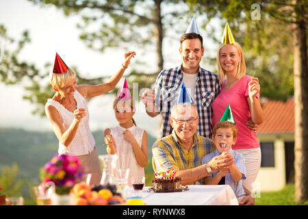 Portrait of a happy family in party hats and sprinklers Stock Photo