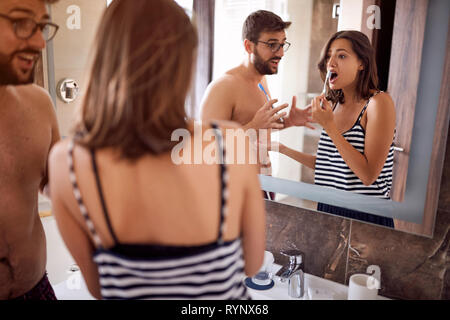 Attractive young couple brushing teeth in morning together Stock Photo