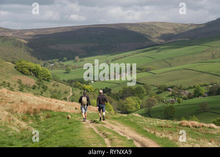 Two men walking in the hills near Hayfield in the Peak District national park, Derbyshire, England. Kinder Scout in the distance. Stock Photo